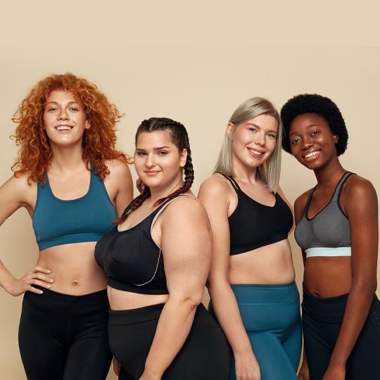 4 women smiling in workout clothing